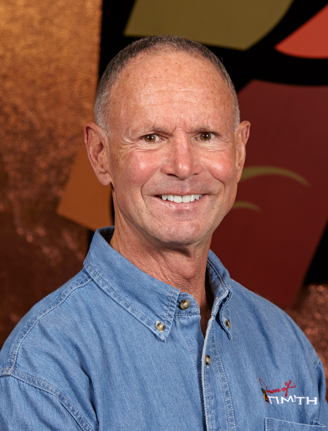 Photograph of Phil Goldstein showing his face, head, and shoulders with the background from inside the lobby of Timnath Town Hall.