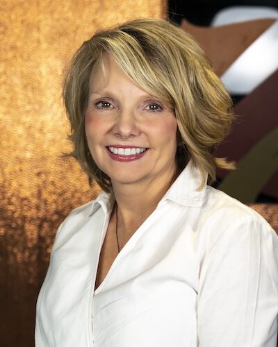 Photograph of Wendy Newlon showing her face, head, and shoulders with the background from inside the lobby of Timnath Town Hall.