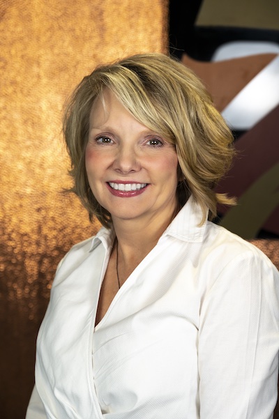 Photograph of Wendy Newlon showing her face, head, and shoulders with the background from inside the lobby of Timnath Town Hall.