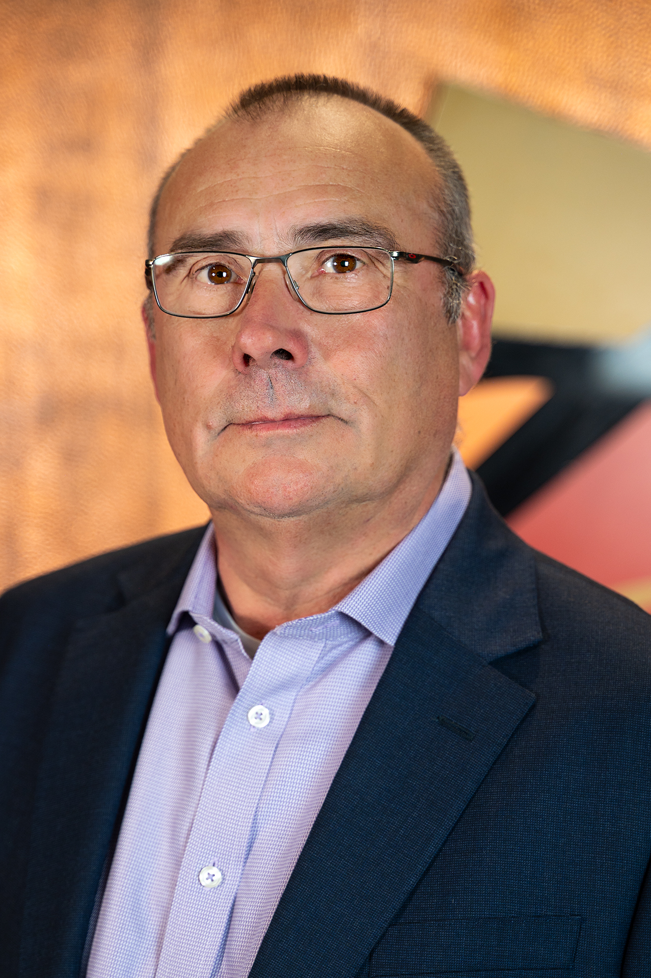 Photograph of Mike Lewis showing his face, head, and shoulders with the background from inside the lobby of Timnath Town Hall.