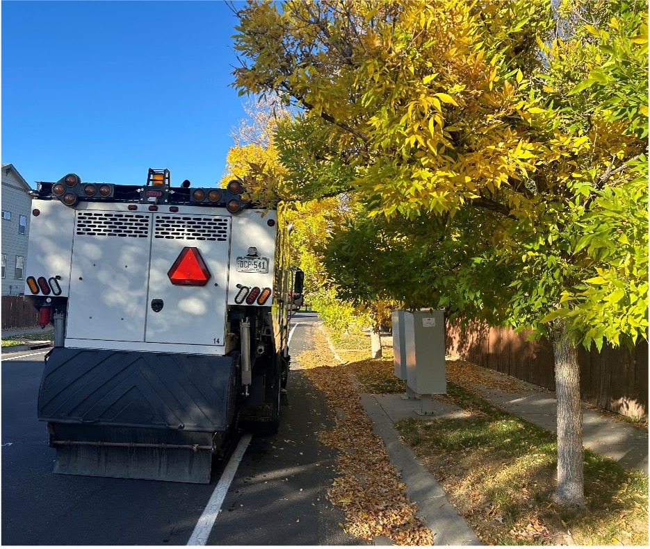 This image shows a street sweeper that unable to access the leaves in the gutter as the adjacent trees have not been pruned to allow 14 feet of clearance over the street.