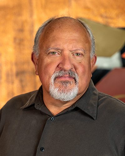 Photograph of Michael Lowry showing his face, head, and shoulders with the background from inside the lobby of Timnath Town Hall.